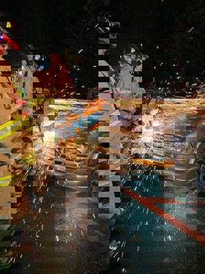 Two Fire Fighters Sawing Car